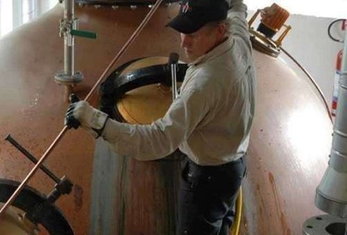 El empleado Tommy Jansson limpiando una caldera en la destilería Mackmyra