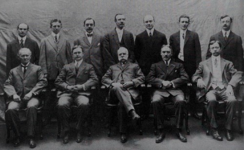 Fotografía de 1910 con los miembros del Departamento de Grabado de la American Bank Note, en la que podemos ver a Edwin Gunn, joven y confiado. De pie, de izquierda a derecha: Clifford H. Dawson, George Hannweber, Elie Timothée Loizeaux, William J. Brown, Harry P. Dawson, Harold Osborn y Louis A. O. Delnoce. Y sentados, en igual orden: Charles Schlecht, Edwin Gunn, Charles Skinner, Robert Savage y Alexander Cordukes