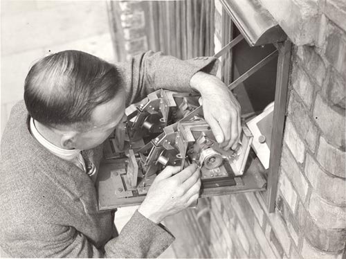 A man refills a stamp vending machine, 1935..jpg