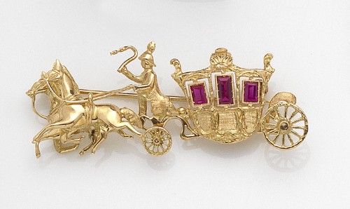 Original alfiler en forma de carroza con pareja de caballos y guía, realizado en oro amarillo de 18 K, con tres rubíes sintéticos en talla baguette a modo de ventanas.jpg