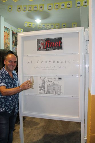 Cartel anunciador de la XI Convención y el Secretario presentándolo.